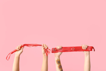 Female hands with sex toys on pink background - obrazy, fototapety, plakaty