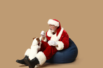 Santa Claus with cute Jack Russell Terrier dog on brown background