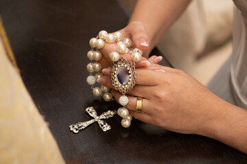 bride holding a ring, hands of the bride, rosary of pearls, rosary for wedding, rosary with large cross, catholic third, bride holding rosary