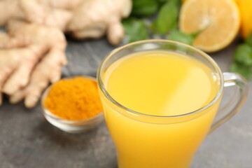 Immunity boosting drink and ingredients on grey table, closeup