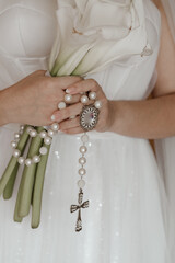 bride holding a ring, hands of the bride, rosary of pearls, rosary for wedding, rosary with large cross, catholic third, bride holding rosary