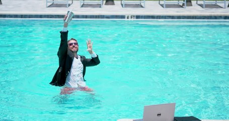Businessman in suit with laptop in swimming pool. Crazy business man on summer vacation. Excited businessman in wet suit in swim pool. Funny business man, comic business. Remote online working.