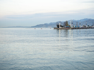 Port area on the Black Sea in winter. Sea cityscape at dusk. Batumi seaport. Industrial zone.