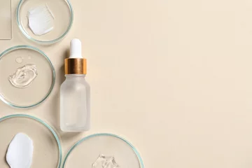 Poster Bottle of cosmetic serum and petri dishes with samples on beige background, flat lay. Space for text © New Africa