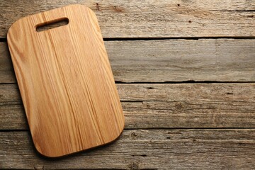 One new cutting board on old wooden table, top view. Space for text