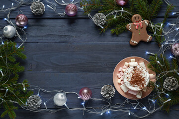 Frame made of tasty cocoa drink, Christmas cookie, fir branches and decorations on dark wooden background