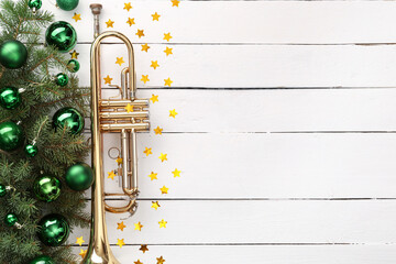 Composition with trumpet, fir branches and Christmas decorations on white wooden background