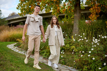 Young Cute Female Hugs Boyfriend. In Autumn Outdoor. Lovers Walking in Park. Attractive Funny Couple. Lovestory in Forest. Man and Woman. Cute Lovers in the Park. Family Concept. Happy Couple.