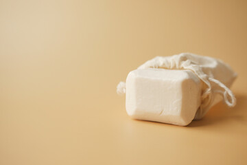 natural soap bar and bag on light orange background 