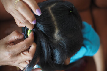 Naklejka premium Mother makes her daughter's hair and braids.
