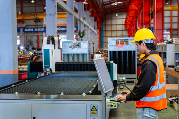 Engineering technician worker is operating the machine inside factory using touch screen computer monitor to command the order for line production and steel industry - obrazy, fototapety, plakaty