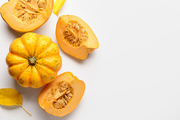 Fresh pumpkins and autumn leaves on white background