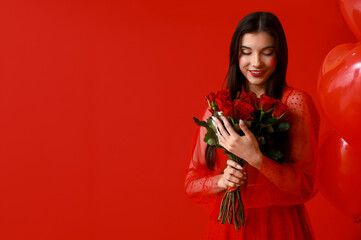 Beautiful young woman with kiss marks on her face holding bouquet of roses and heart shaped air...