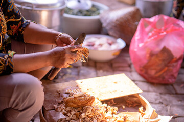 a mother is sitting and cutting chicken for a meal in the kitchen