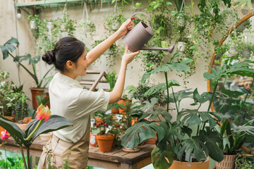 Portrait of Asian woman working in a plant shop - Powered by Adobe
