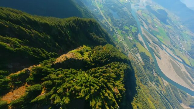Flight along the mountain range by FPV Drone, Fraser river valley below. Canada