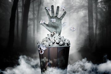 Scary hand coming from popcorn bucket, Halloween concept