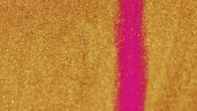 Wet glitter spill. Metallic paint texture. Bright pink gold color shiny wet ink drip blend flow motion on blur art abstract background.