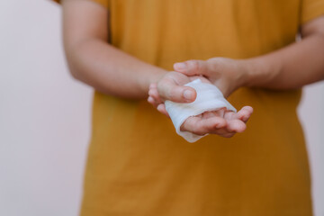 A person in a yellow top has white bandages on their hand and wrist because of a car accident.