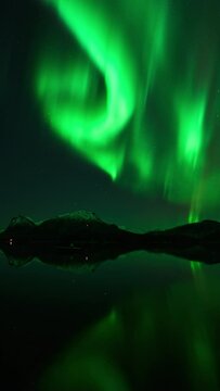 Beautiful colorful reflections from an aurora in a crystal clear lake.