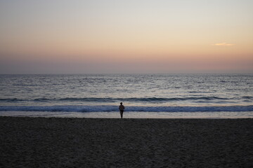 Fototapeta na wymiar A person walking on the beach at sunrise, Bondi Beach, Sydney Australia 