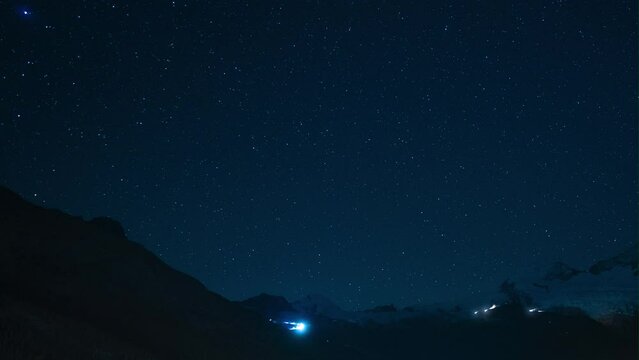 Cinematic Switzerland Saas Fee Glacier Gletscher star Timelapse mountain milky way snow making cat track groomer lights up and down the peak stunning clear deep blue evening night sky stunning still