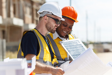 Contractors discuss about solar panel installation on modern building.