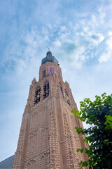 Fototapeta na wymiar Captured in this image is the awe-inspiring tower of the church in Hoogstraten, a striking example of Gothic architecture. As the tower ascends towards the heavens, its intricate brickwork and
