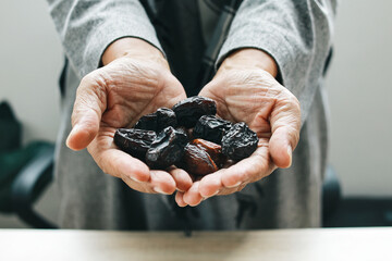 Hands holding dates fruit on palm. Natural healthy food product to break ramadan fasting