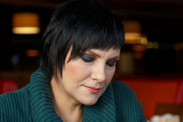 Woman with short hair and makeup.