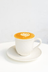 A cup of hot coffee latte with latte art on white table