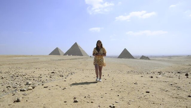 Travel girl walks and Giza Pyramids. Egyptian landscape. Egypt. Tourist woman