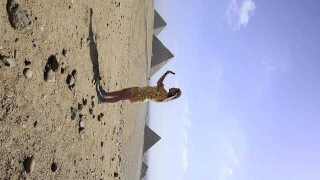 Influencer girl records video in front of egyptian pyramids in Giza, Egypt. Travel youtuber. Vertical