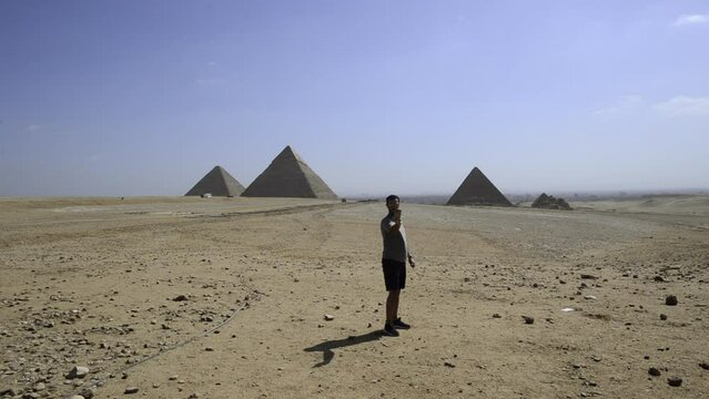 Traveler influencer man takes selfie pohoto at the Giza Piramids, Egypt. Tourist man