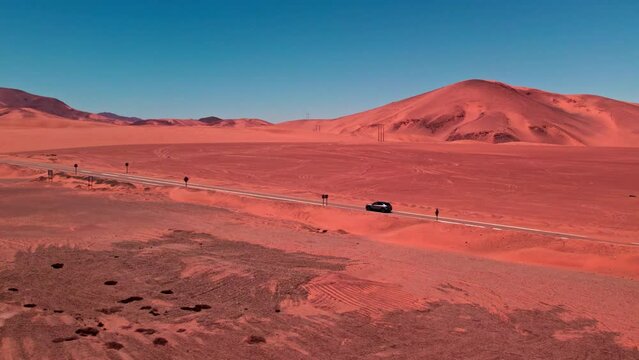 Aerial view of a car driving on a road in middle of dunes in Coquimbo, Chile