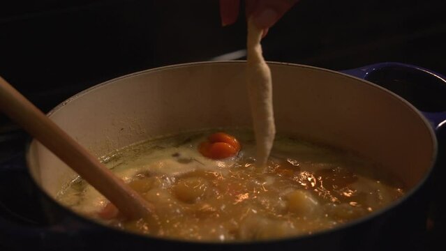 Adding dumplings to boiling pot Preparing jamaican gungo pea soup after being picked from tree healthy green fresh protein cultivation harvested