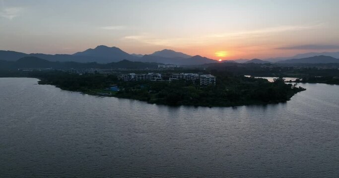 Aerial footage of sunset over lake and mountains