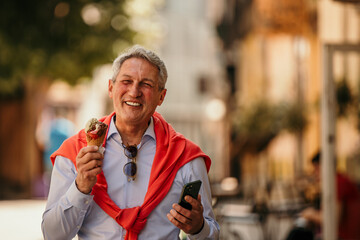 Senior executive on a city stroll, savoring an ice cream cone