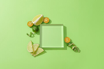 A transparent glass podium is placed on a green background, surrounded by fresh lemons and...