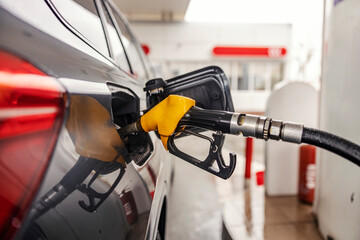Close up of fuel nozzle fulling a car tank.