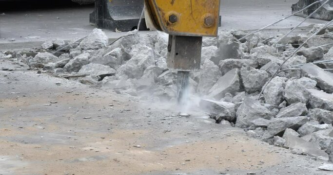close of a bulldozer broke up a road with a jackhammer