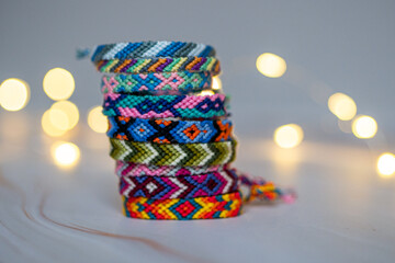 Pile de bracelets brésiliens artisanaux devant un fond en bokeh