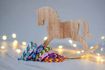 Petit cheval à bascule en bois avec fond en bokeh et bracelets brésiliens