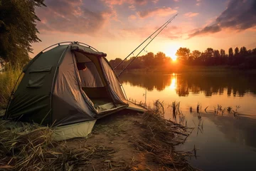 Selbstklebende Fototapeten Close up of carp fishing tent and rods in background of lake and beautiful sunset. Lifestyle concept of holiday and hobby. © cwa