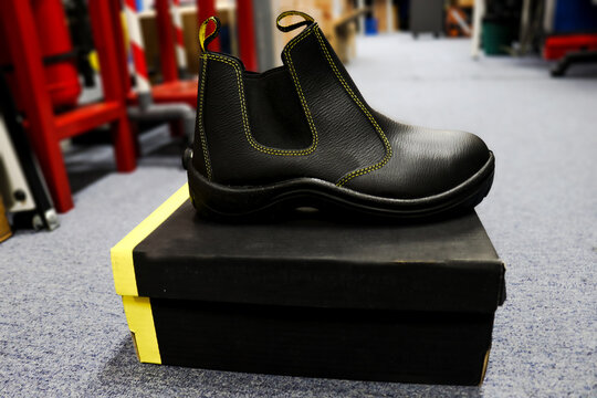 Photo of black leather safety boots with box