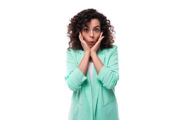 surprised young brunette curly businesswoman in a jacket on a white background
