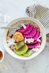 Chia pudding with tropical fruits: pittaya, kiwi, coconut and peanut butter.