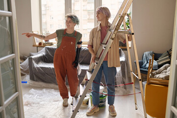 Two girls discussing the moment of future repair in their new apartment