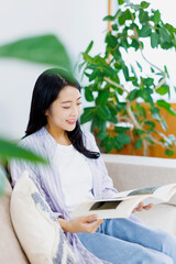 リビングルームで本を読んでいる女性