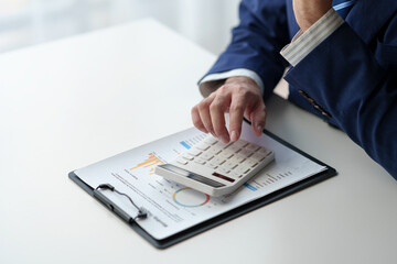 Businessman uses pen to point at chart Graph and use ideas to analyze financial reporting situations. Calculate your investments with the income, tax and accounting calculators at your desk.